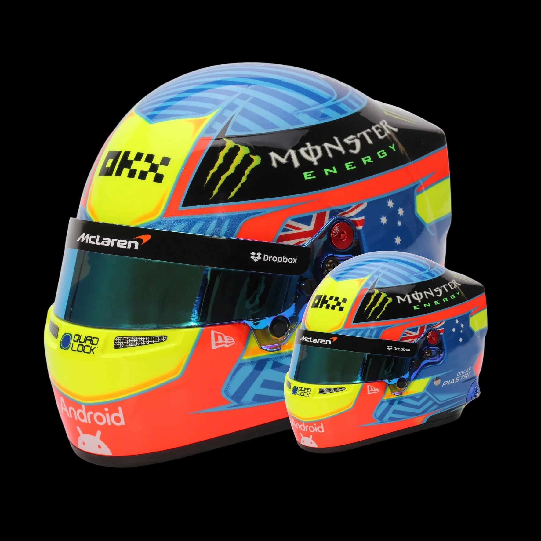 A miniature replica of an F1 racing helmet used by Oscar Piastri, featuring bright colors and Australian flag elements, alongside a real-size racing helmet.