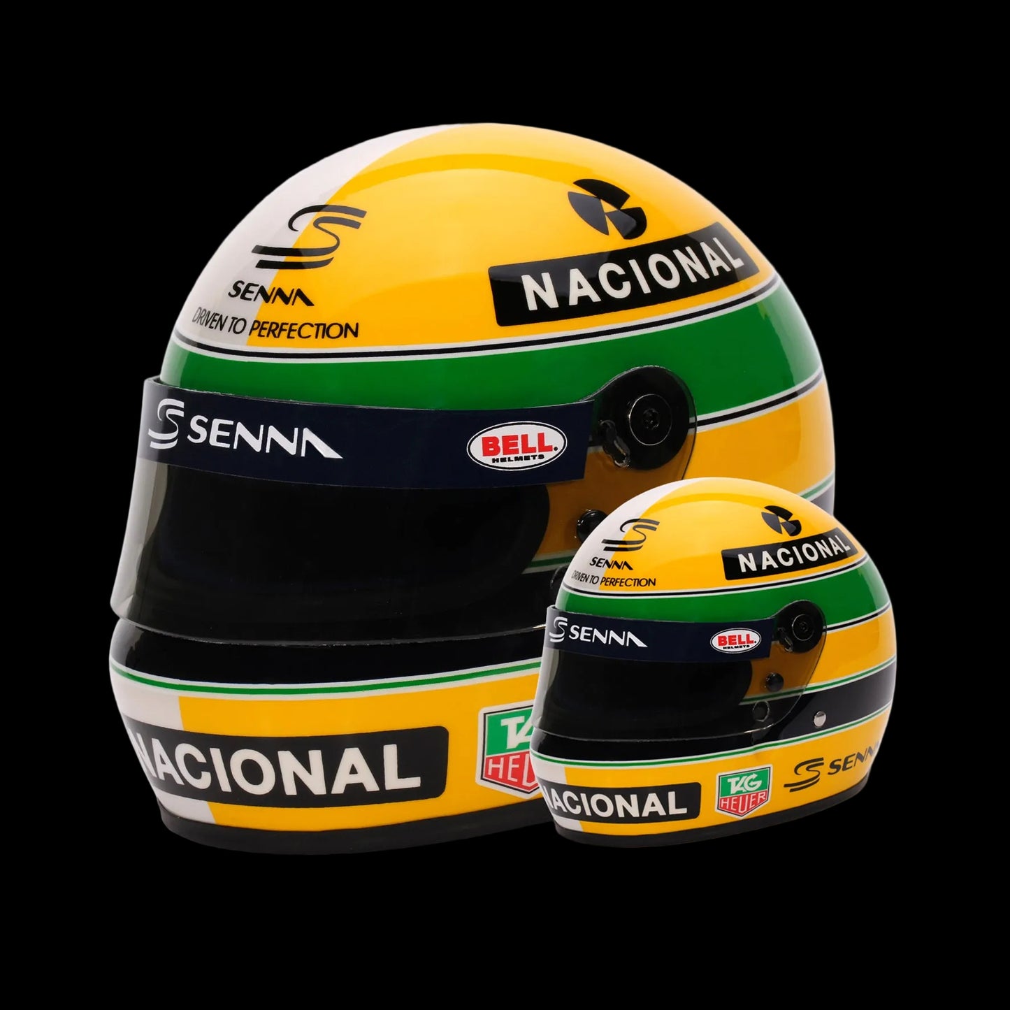 A collection of two mini Bell helmets, one full-sized and one miniature, both featuring Ayrton Senna branding and in yellow, green, and blue livery.