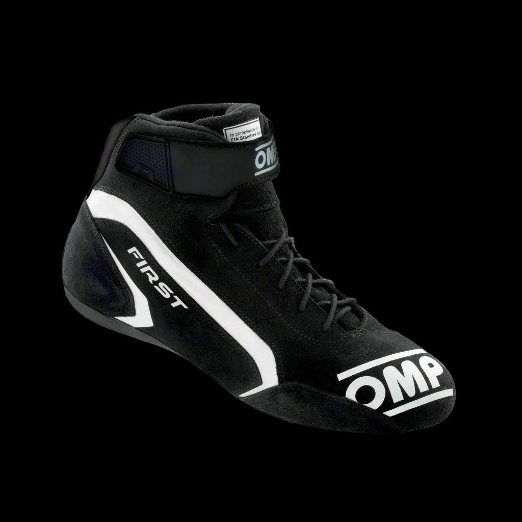A single OMP 'FIRST' circuit racing boot in black color with a white logo, showcasing the side profile of the boot with the ankle strap and brand markings.