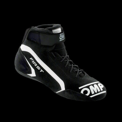 A single OMP 'FIRST' circuit racing boot in black color with a white logo, showcasing the side profile of the boot with the ankle strap and brand markings.