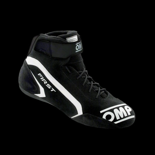 A single OMP 'FIRST' circuit racing boot in black color with a white logo, showcasing the side profile of the boot with the ankle strap and brand markings.