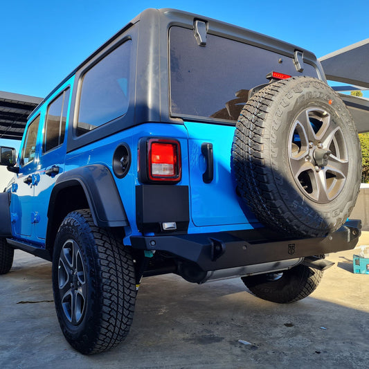 A close-up image of a blue Wrangler JL with a black RockRage OUTLAW Stubby Rear Bumper installed on the vehicle.
