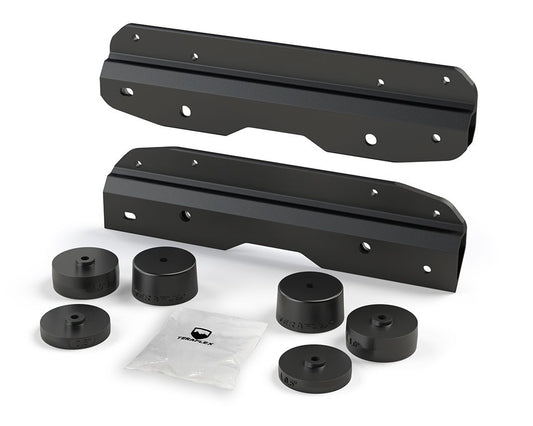 A black metal bracket kit, including various spacers and mounting hardware, designed for relocating the spare tire on a Jeep Wrangler JL or JLU.