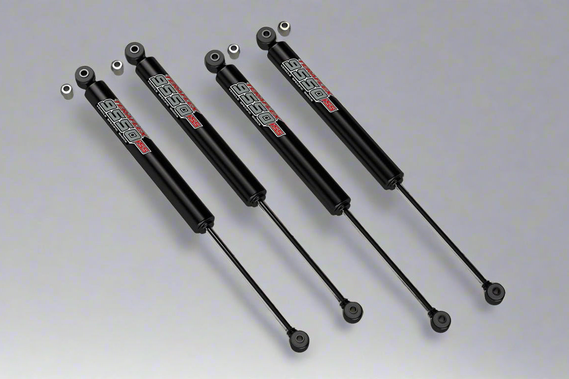 A set of four Teraflex 9550 2.5" lift shocks for Wrangler JL / JLU 2019+ vehicles, displayed against a grey background.